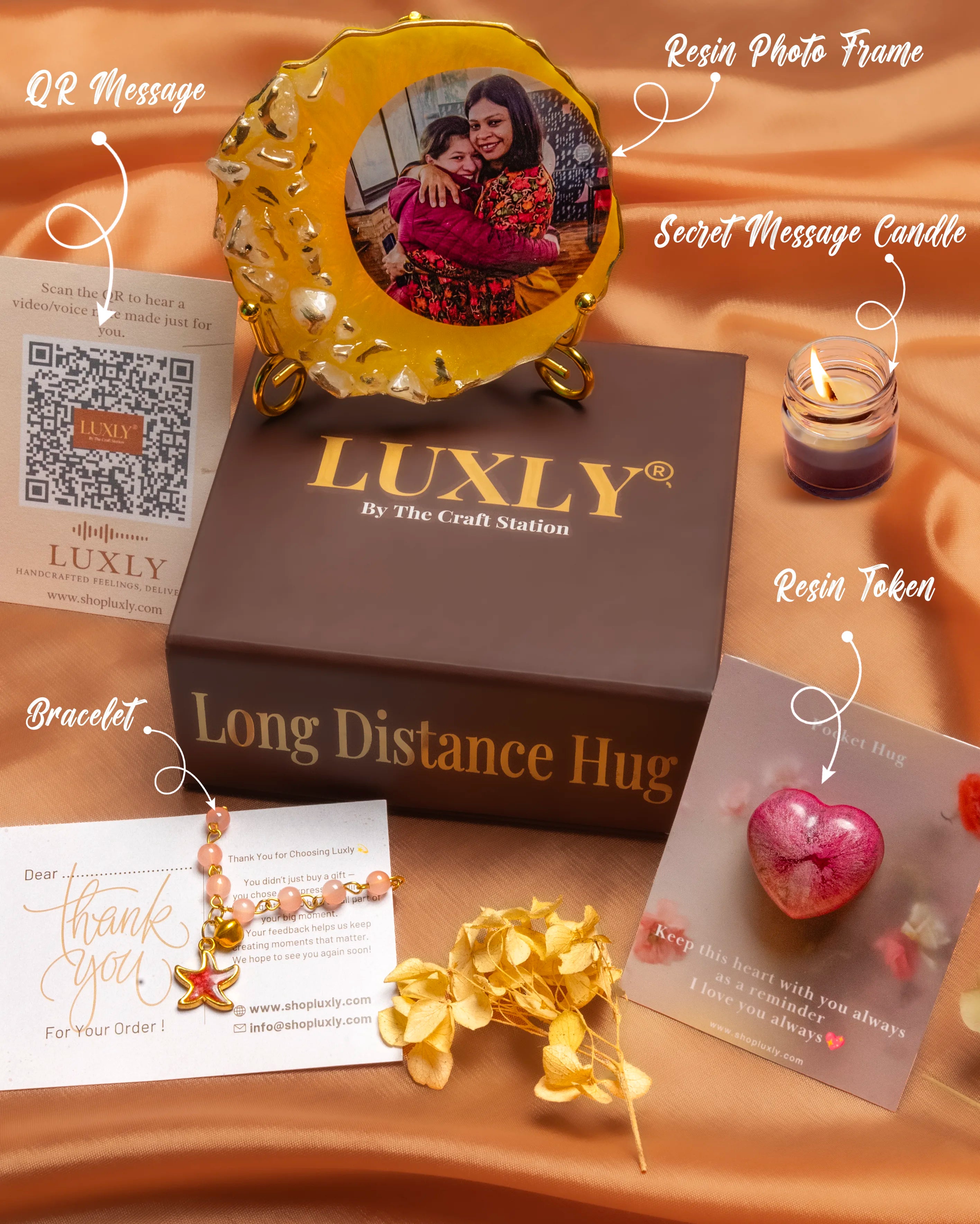Luxly product display with photo frame, candle, and jewelry on a brown surface