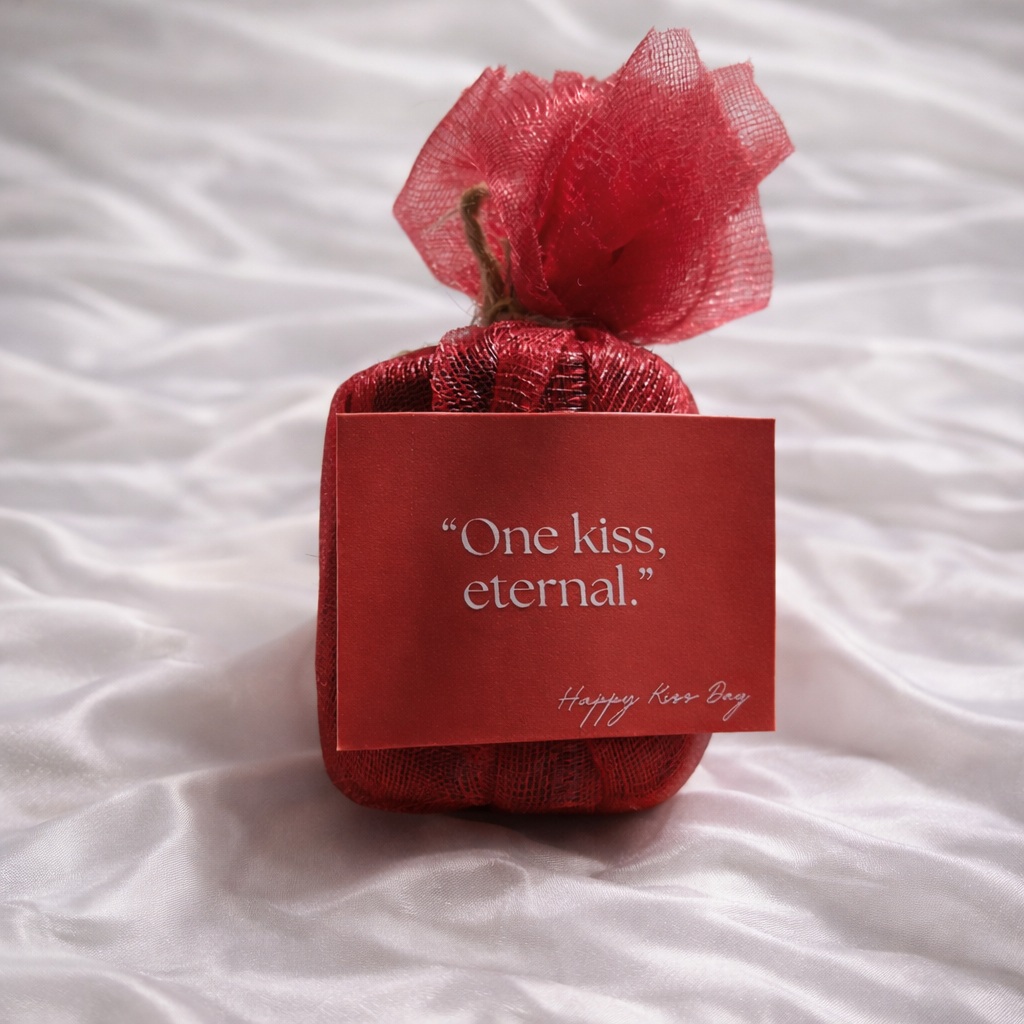 Red gift box with a bow and card on a white fabric background